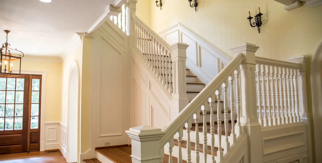Escaleras de madera. Detalle de escalera de madera blanca en salón moderno.