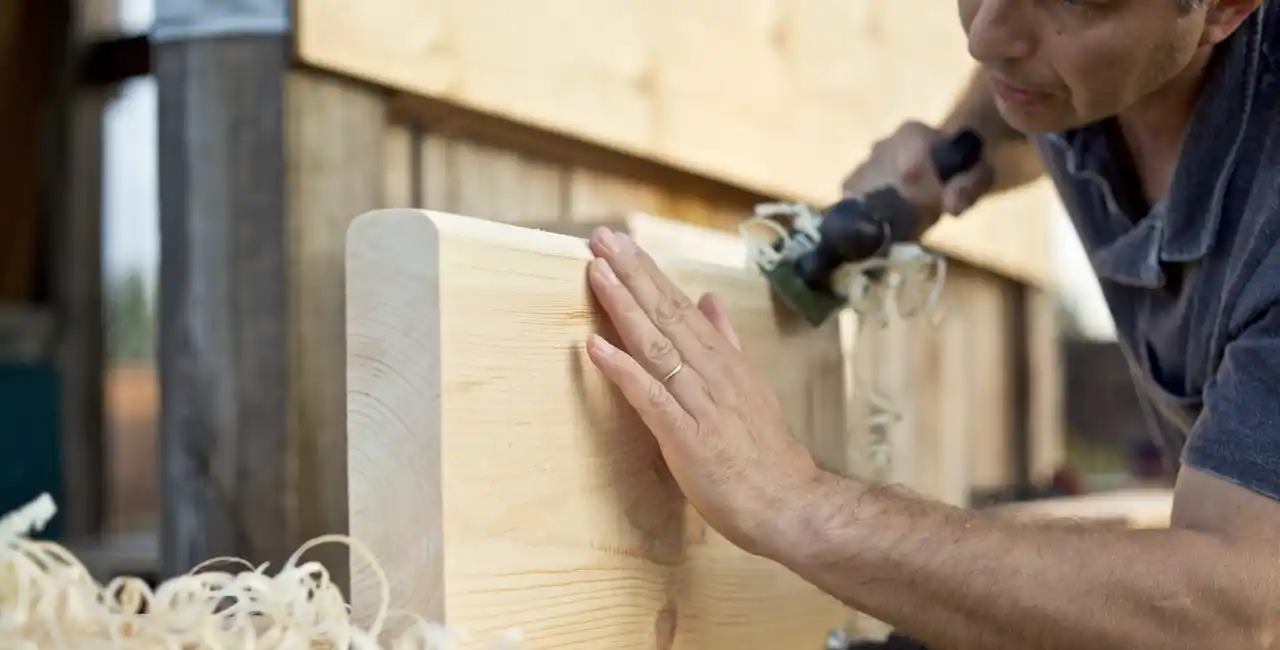 Maderas para peldaños de escalera roble haya sapelly comparativa. Trabajador lijando madera para peldaño