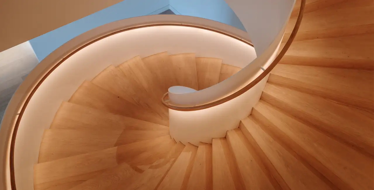 Peldaños de madera maciza y laminados comparados en una escalera interior moderna