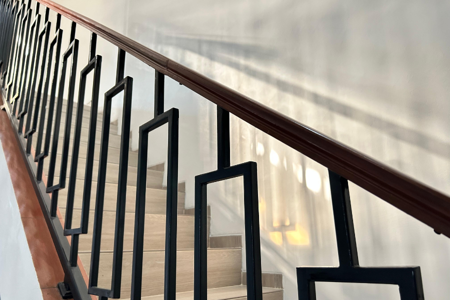 Barandilla de madera y metal en escalera interior moderna con diseño contemporáneo