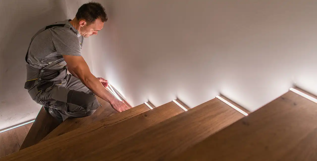 Instalar peldaños de madera en escaleras. Operario instalando peldaños en escalera de madera.